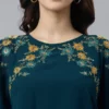 Top a trapezio decorato in georgette blu acquamarina